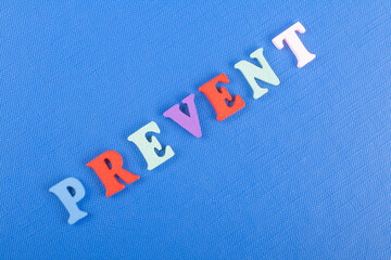 PREVENT word on blue background composed from colorful abc alphabet block wooden letters, copy...