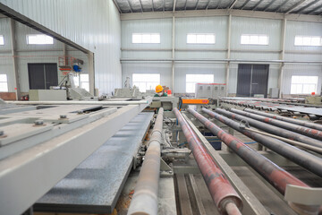 Workers work nervously on the production line of new building materials calcium silicate board,...