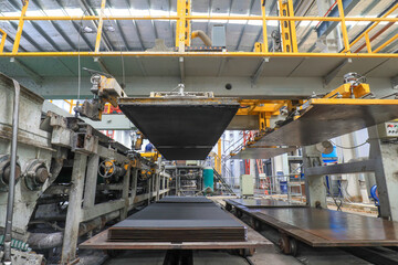 Workers work nervously on the production line of new building materials calcium silicate board,...