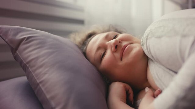 Close-up of overweight young woman sleeping in bed, healthy sleep, home comfort