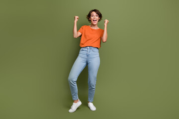 Photo of positive excited lady raise fists up impressed incredible win lottery shopping offers isolated over green background - obrazy, fototapety, plakaty
