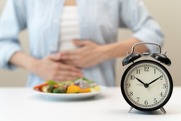 Intermittent fasting concept, Close-up on clock and people feeling hungry waiting time to eat...