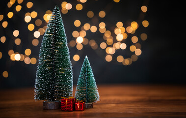 Christmas trees on the table with bokeh lights on the background, Merry Christmas greeting poster...