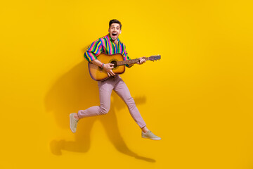 Fototapeta na wymiar Full body photo addicted meloman professional musician guy holding guitar touching strings performance isolated on yellow color background