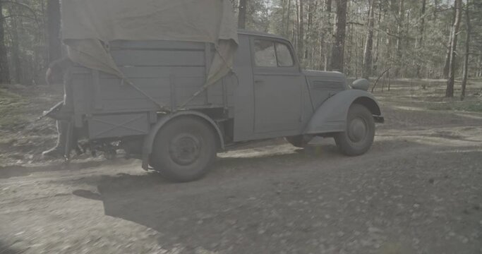 German Vehicle Truck Opel Blitz Driving By Forest Road In Autumn Season. Military Truck Opel. Reenactment Tactic Game. German Wehrmacht World War Ii Military Automotive. Ungraded C-log 2.