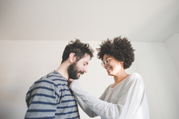 Young multiethnic couple having fun smiling together at home