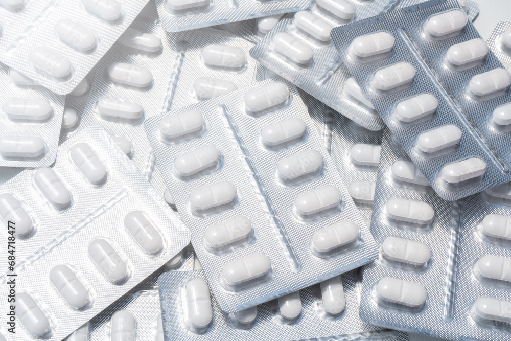 Poster pack of white pills stacked in daylight