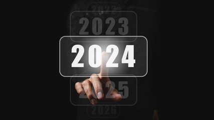 The beginning of the new year 2024. A man's hand chooses 2024, planning and strategy for tasks in...