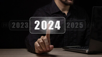 The beginning of the new year 2024. A man's hand chooses 2024, planning and strategy for tasks in...