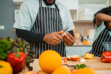 Kind African american parents teaching their adorable daughter how to cook healthy food, free space of kitchen, Happy black people family preparing healthy food in kitchen together - obrazy, fototapety, plakaty