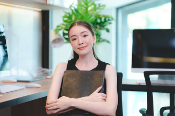 Fototapeta na wymiar Portrait of smart young beautiful Asian business woman, successful female employee smiling with happy job, financial woman satisfied with the results of her work achievement in modern office