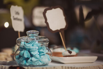 Baby shower event, decorations and cakes in blue colour. Sweets and cake on the table ready for party. A beautiful sweet candy bar with muffins, cakes, fruits, marshmallows and toppers.