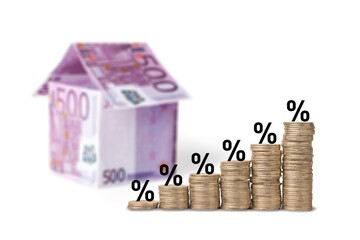 Stack coins and interest rates with toy house