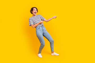 Fototapeta na wymiar Full body profile portrait of cheerful impressed lady arms pull empty space rope isolated on yellow color background