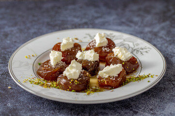 Traditional stuffed dried fig dessert with walnuts and cream, cooked with syrup (Turkish name: fig dessert with cream).​