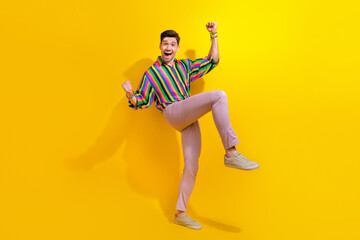 Fototapeta na wymiar Full body length photo of excited guy celebrate his victory in competition between dancers in nightclub isolated on yellow color background