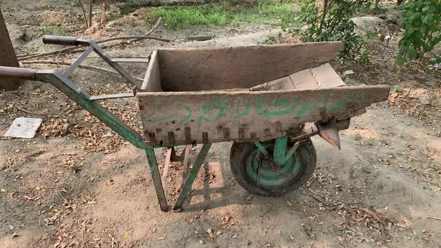 Pakisatni Wooden Wheel Barrow. The back of the wheel barrow on the yard with the handle and the wheels infront in pakistan. Modified woodn trolley with farm usag.