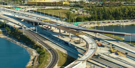 Construction roadworks on american transport infrastructure. Renovation of highway road interchange with moving traffic in Miami, Florida. Development of interstate transportation concept