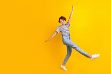 Tuinposter Full length portrait of positive carefree person chilling dancing empty space isolated on yellow color background © deagreez