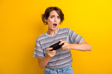 Portrait of upset astonished girl with short hairstyle wear grey t-shirt hold joystick lose game...