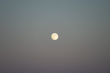 Full moon against a subtitle sunset sky.