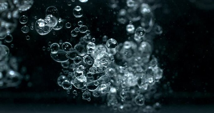 Slow motion macro of floating micro particles molecules in liquid are analyzed with microscope by chemist during innovative new medical research and analysis in scientific pharmaceutical laboratory.