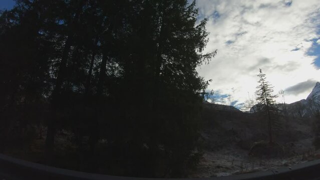 TRAVELLING SLOW MOTION SHOT - Beautiful alpine winter view with a building and the famous Ehrwalder Sonnenspitze and Zugspitze in the background at the Ehrwalder Alm near Ehrwald, Tyrol, Austria.