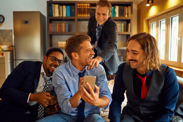 Group of friends taking selfie, happy men enjoying party at home, multiethnic males with drinks, casual gathering