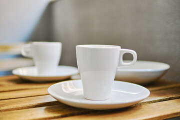 Two white tea cups on table in terraced area