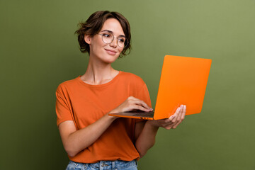 Photo of smart clever girl with bob hairdo dressed orange t-shirt in glasses look at laptop read...