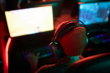 High angle view at unrecognizable gamer playing videogames in dark with red neon light, copy space © Seventyfour