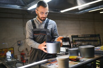 printing house, experimented technician works on UV printer. Production work