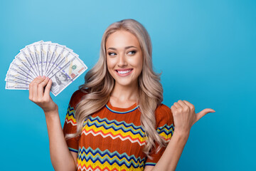 Photo of pretty dreamy girl dressed print shirt holding money fan looking showing thumb empty space...