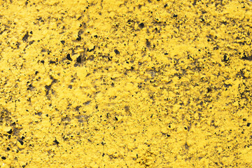 Yellow paint on black surface. Stucco wall texture. Yellow paint asphalt. Distressed noise backdrop...