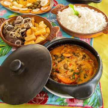 Pratos t&iacute;picos nordestinos do Brasil, em panelas de barro com comidas variadas em uma mesa farta