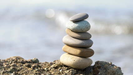 Stone cairn pyramid at seaside. Stack of balanced stones on the beach. 
