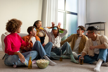 multiracial group of young friends playing charades drinking beer and having fun at home - obrazy, fototapety, plakaty