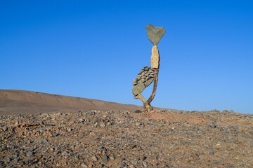 a rock art piece stands in the desert near the water