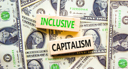 Inclusive capitalism symbol. Concept words Inclusive capitalism on beautiful wooden blocks. Dollar bills. Beautiful background from dollar bills. Business inclusive capitalism concept. Copy space.