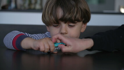 Two little boys fighting over toy car. Older brother wanting to take vehicle object from sibling