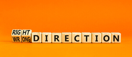 Right or wrong direction symbol. Concept words Right direction Wrong direction on wooden blocks. Beautiful orange table orange background. Business right or wrong direction concept. Copy space.