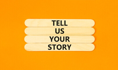 Tell us your story symbol. Concept word Tell us your story on beautiful wooden stick. Beautiful orange table orange background. Business tell us your story concept. Copy space.