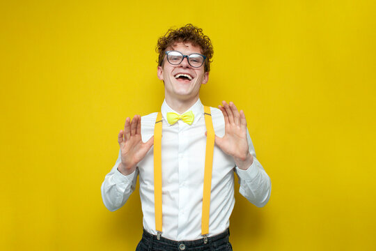 confident cheerful guy in festive outfit and glasses rejoice, nerd student in bow-tie shirt and suspenders