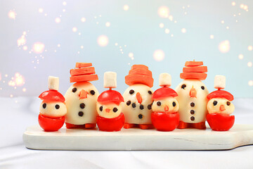 Christmas New Year's dishes, funny figures of snowmen made from eggs, mozzarella cheese, tomatoes...