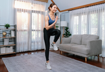 Energetic and strong athletic asian woman running in place at her home. Pursuit of fit physique and commitment to healthy lifestyle with home workout and training. Vigorous