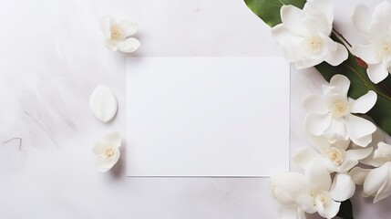 A wedding card that is flat laid and has white flowers as decorations.