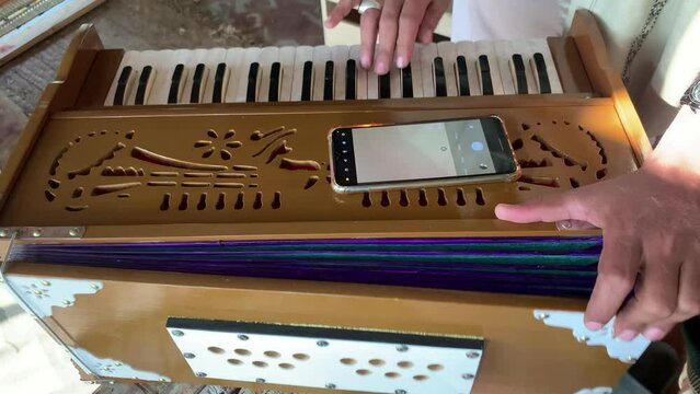 A Man Playing Harmonium. Closeup shot of hands of a Man playing Harmonium. Traditional world. Folk instrument. Pakistani man playing harmonium in the house. Beautiful 4K Footage.