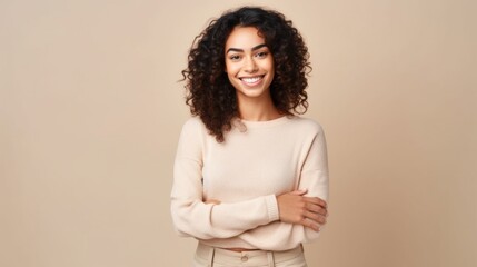 Obraz premium In a light beige studio, a joyful multicultural woman strikes a pose.