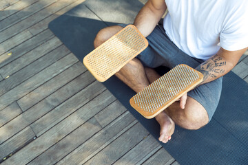 Serene yogi sitting in lotus position holding sacred sadhu boards.