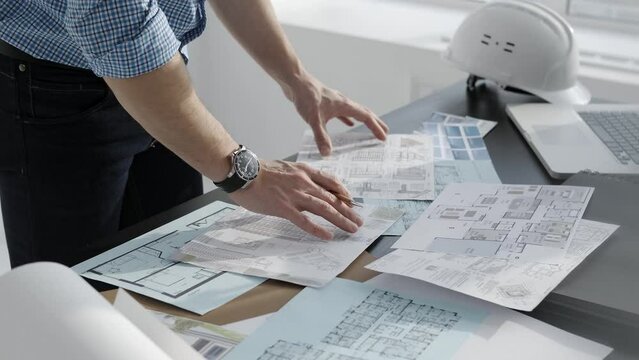 The architect at work: designing buildings, working with layouts and technical drawings. Close-up paper on the table.